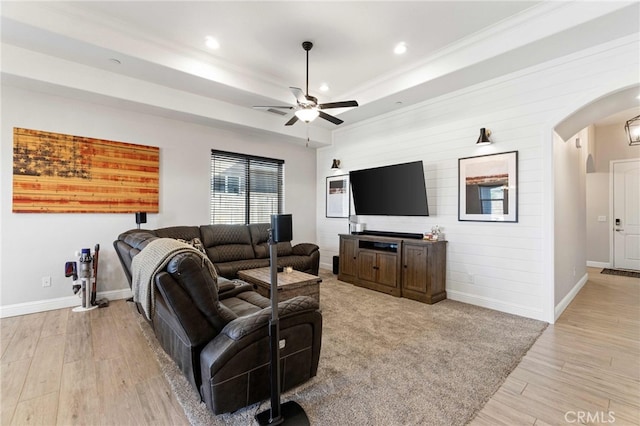 living room with arched walkways, recessed lighting, a ceiling fan, baseboards, and light wood-type flooring