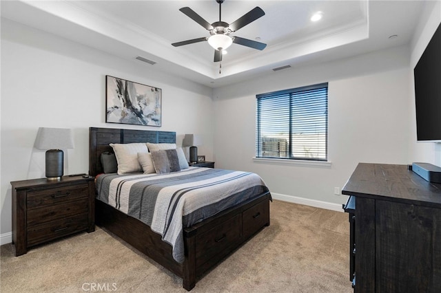 bedroom with visible vents, a tray ceiling, and baseboards