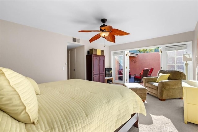 bedroom featuring a ceiling fan, visible vents, and light colored carpet