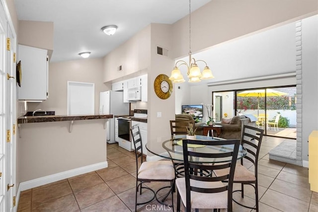 dining space featuring a notable chandelier, visible vents, light tile patterned flooring, high vaulted ceiling, and baseboards