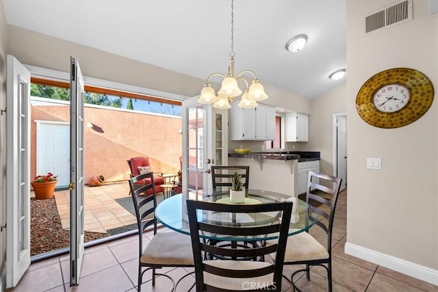 dining area with light tile patterned floors, visible vents, lofted ceiling, french doors, and a notable chandelier