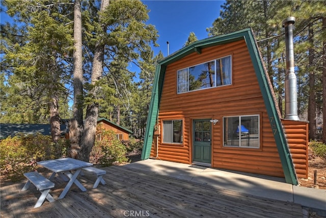 exterior space featuring a deck and log veneer siding