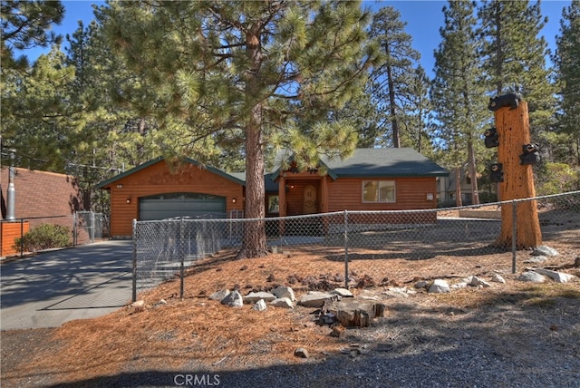 rustic home with log veneer siding, driveway, an attached garage, and fence