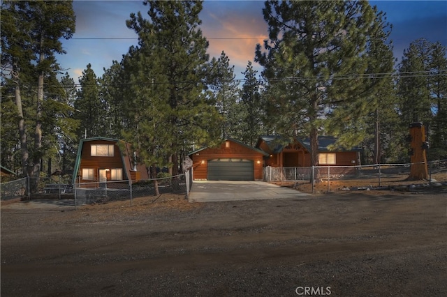 view of front of home featuring a garage, a fenced front yard, and concrete driveway