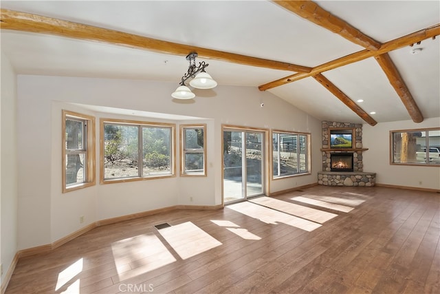 unfurnished living room with vaulted ceiling with beams, a fireplace, visible vents, baseboards, and light wood finished floors