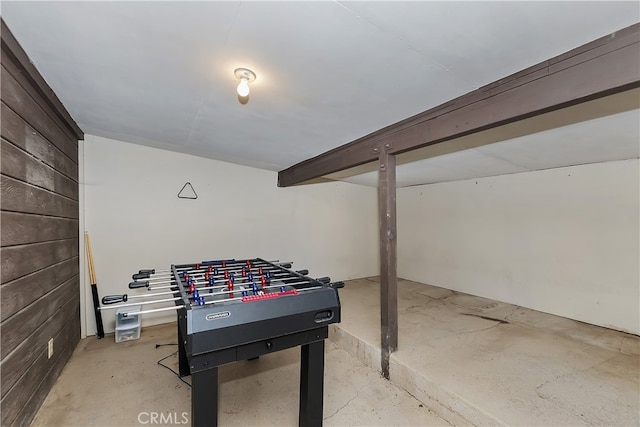 game room featuring concrete flooring and wooden walls