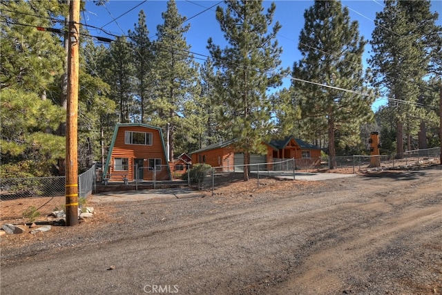 view of front of home featuring driveway and fence