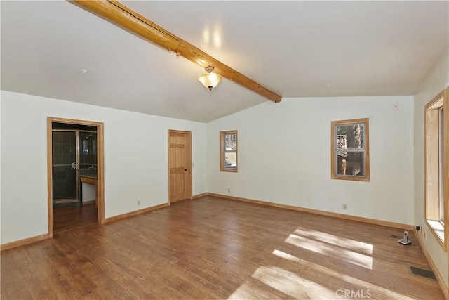 empty room featuring visible vents, vaulted ceiling with beams, baseboards, and wood finished floors