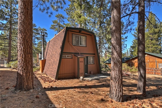 exterior space featuring roof with shingles and a gambrel roof