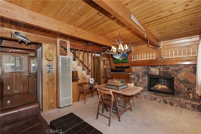 dining room with beam ceiling, a fireplace, wood ceiling, a heating unit, and wood walls