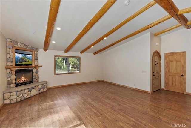 unfurnished living room featuring vaulted ceiling with beams, a fireplace, wood finished floors, and baseboards