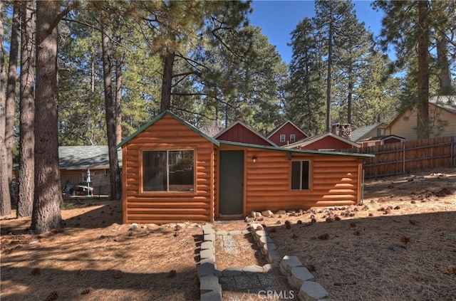 log cabin with fence, an outbuilding, board and batten siding, and log veneer siding