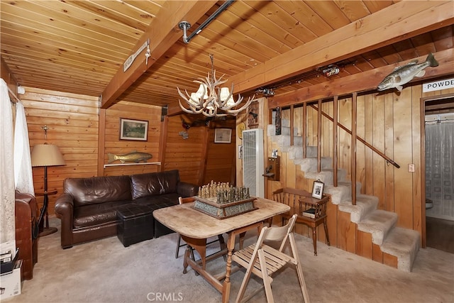 carpeted living room with wood walls, wood ceiling, stairway, and beamed ceiling