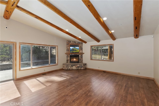 unfurnished living room with lofted ceiling with beams, a stone fireplace, wood finished floors, and baseboards