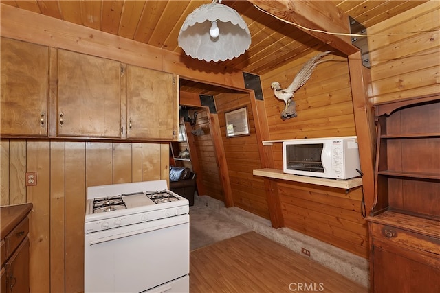 kitchen with white appliances, wooden ceiling, brown cabinets, and wooden walls