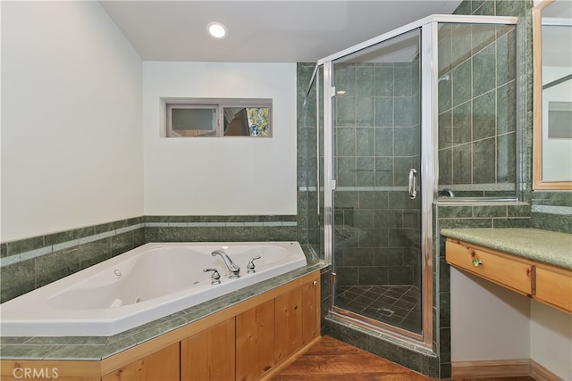 bathroom with a stall shower, a jetted tub, and recessed lighting