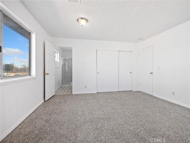 unfurnished bedroom with a closet, a textured ceiling, baseboards, and carpet flooring