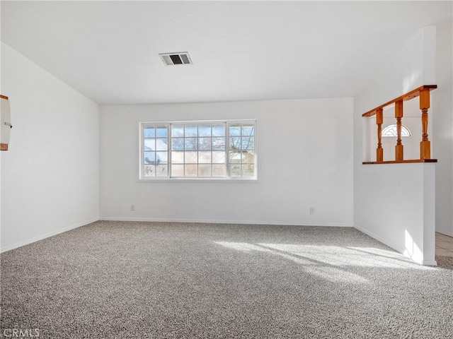 spare room featuring carpet flooring, visible vents, and baseboards