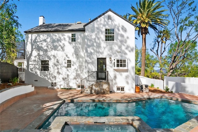 rear view of house with a patio, a balcony, fence, a fenced in pool, and a chimney