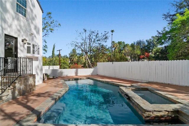 view of pool featuring a pool with connected hot tub and a fenced backyard