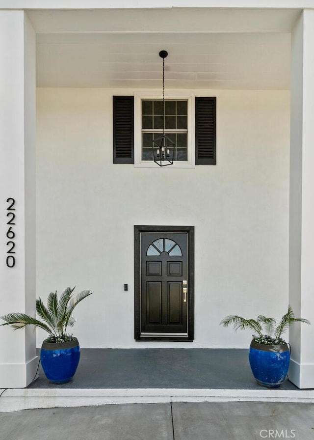 doorway to property featuring stucco siding