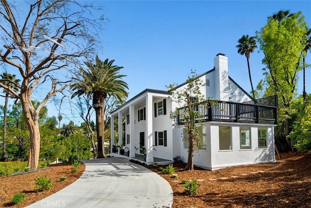 view of property exterior with a chimney and stucco siding