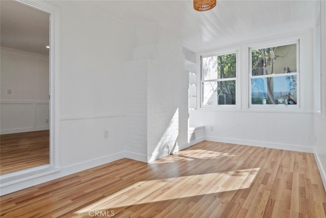 empty room with wainscoting and light wood-style floors