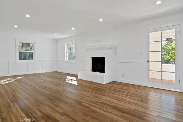 unfurnished living room featuring dark wood-type flooring, a fireplace, and a decorative wall