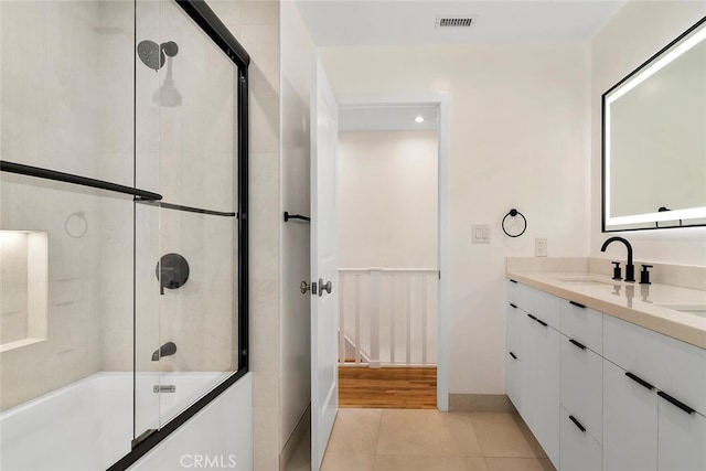 full bathroom with visible vents, combined bath / shower with glass door, vanity, tile patterned flooring, and baseboards