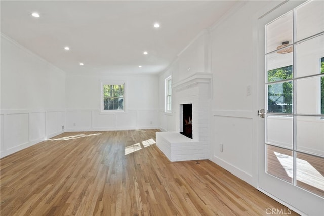 unfurnished living room featuring ornamental molding, a fireplace, and a decorative wall