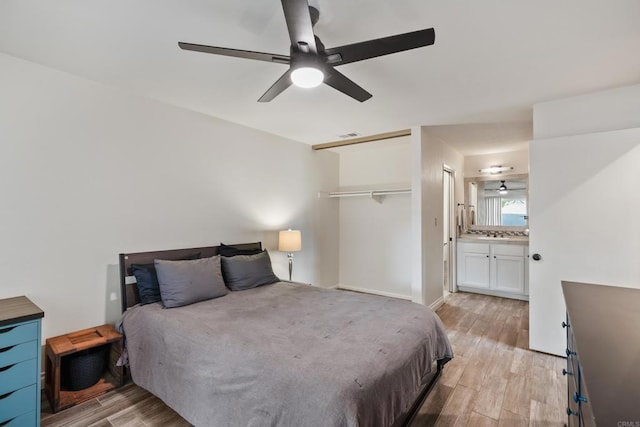 bedroom with a ceiling fan, a closet, light wood-style flooring, and ensuite bathroom