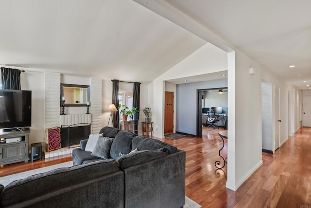 living area with vaulted ceiling with beams, baseboards, and wood finished floors