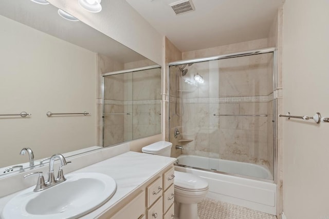 full bathroom featuring visible vents, toilet, shower / bath combination with glass door, tile patterned flooring, and vanity