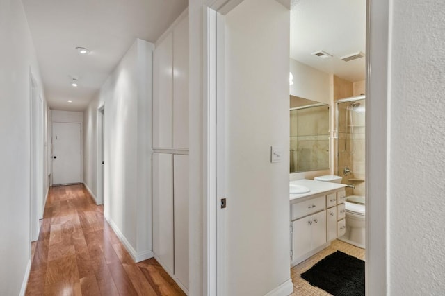 corridor with light wood finished floors and baseboards