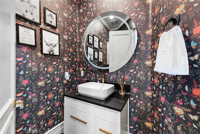 bathroom featuring vanity and wallpapered walls