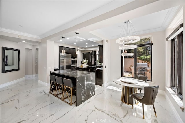 kitchen featuring marble finish floor, appliances with stainless steel finishes, dark stone counters, and ornamental molding