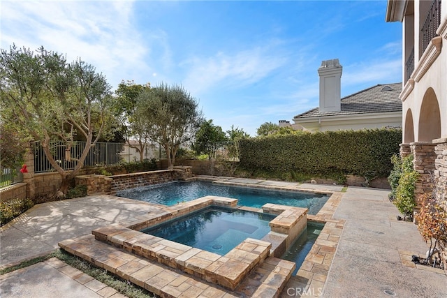 view of pool with a pool with connected hot tub, a fenced backyard, and a patio