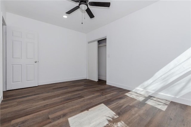 unfurnished bedroom featuring a closet, baseboards, dark wood-type flooring, and recessed lighting