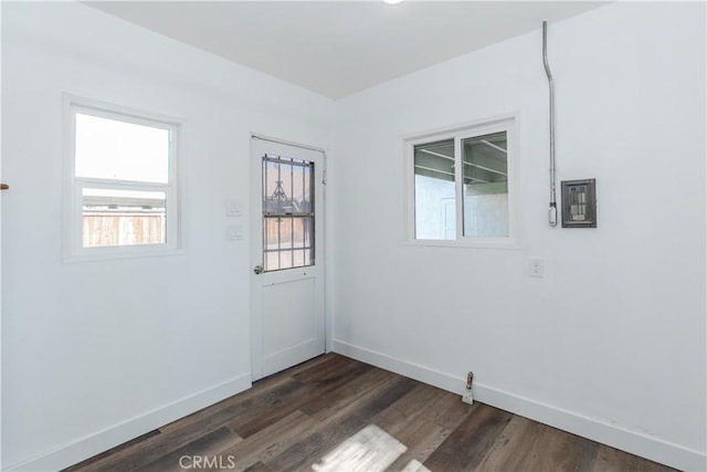 spare room with dark wood-style floors and baseboards