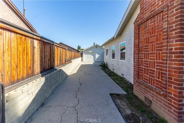 view of home's exterior featuring a patio, a detached garage, crawl space, fence, and stucco siding