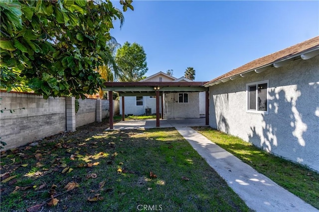 back of property with a lawn, a patio area, a fenced backyard, and stucco siding