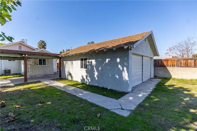 bungalow-style house featuring an outbuilding, central AC unit, a front lawn, and stucco siding