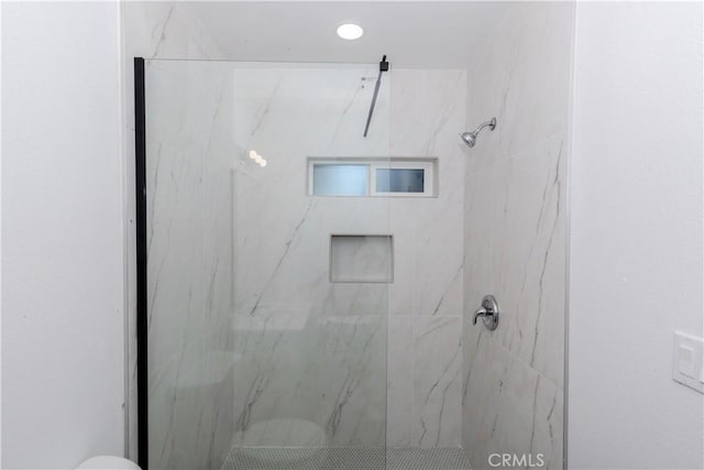 full bath featuring a marble finish shower and toilet