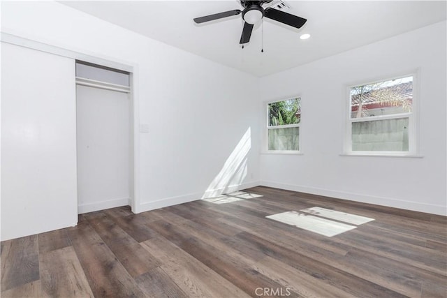 unfurnished bedroom featuring baseboards, dark wood finished floors, and a closet