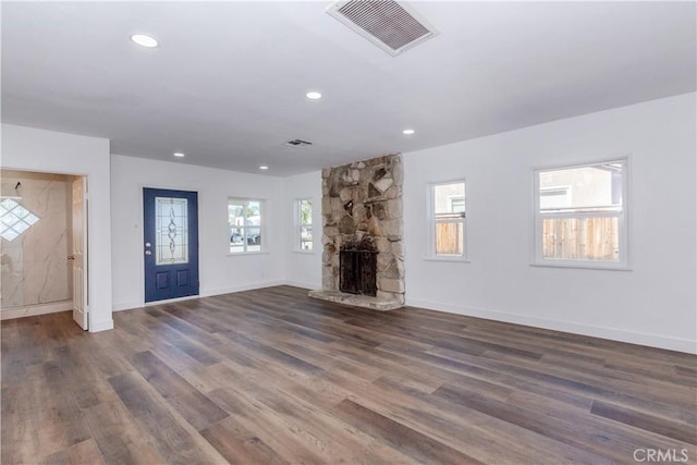 unfurnished living room featuring recessed lighting, dark wood-style flooring, a fireplace, visible vents, and baseboards