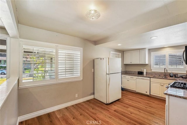 kitchen featuring light wood-type flooring, white appliances, plenty of natural light, and baseboards