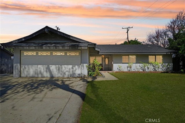 single story home with driveway, a lawn, an attached garage, and stucco siding