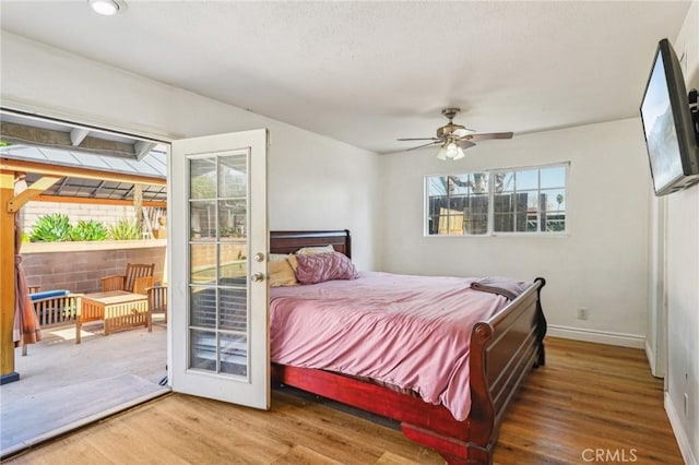 bedroom featuring access to exterior, ceiling fan, baseboards, and wood finished floors