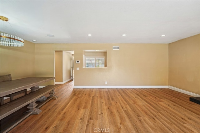 unfurnished room featuring light wood-style floors, visible vents, and baseboards