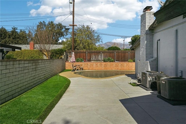 view of patio / terrace with central air condition unit and a fenced backyard